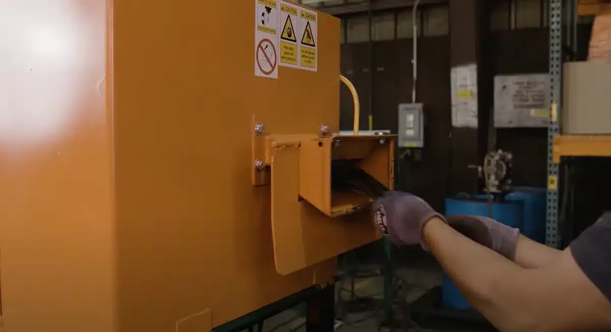 Metal band saw blades being fed into a SWEED model 517 scrap chopper