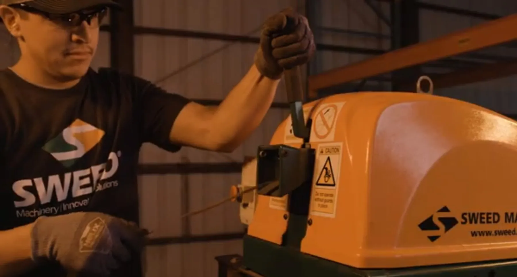 Plastic strap being hand-fed fed into a SWEED scrap chopper Model 450 DDX.